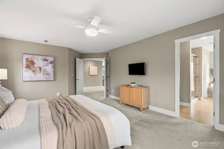 3rd view of primary suite looking toward the ensuite bath and the french doors that lead out to the hallway.