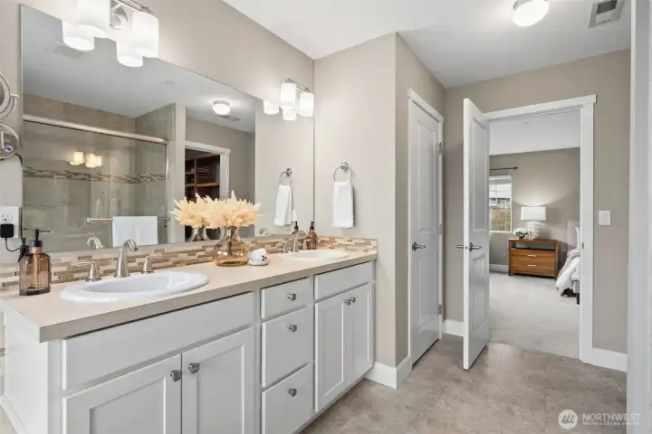 Primary ensuite with soaking tub, large walk in shower, double vanity and large walk in closet with custom shelving.