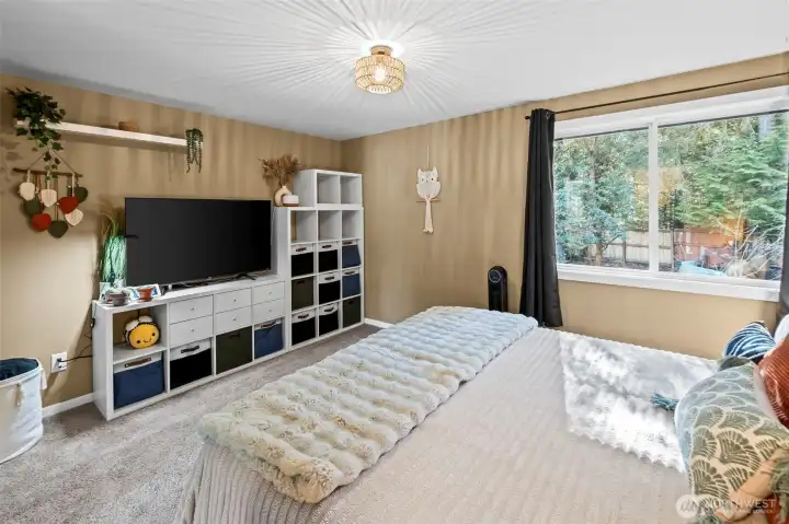 Spacious primary with picture window looking towards the backyard.