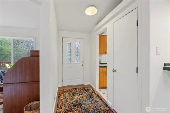 View of the front door with the kitchen to the right and den/office to the left.