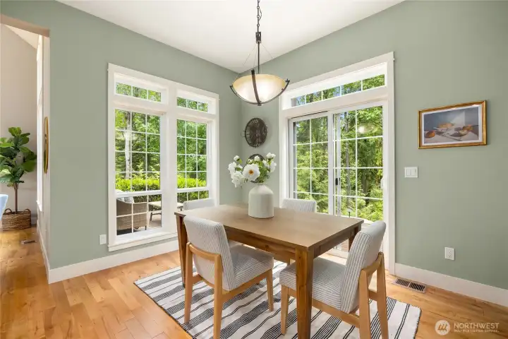 The bright dining area overlooks the forested back yard.