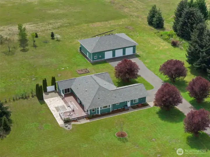 Large rambler home with a 2,400 sq ft shop with 10K lift, multiple oversized doors (3–10', 1–12'), and 3/4 bath with laundry