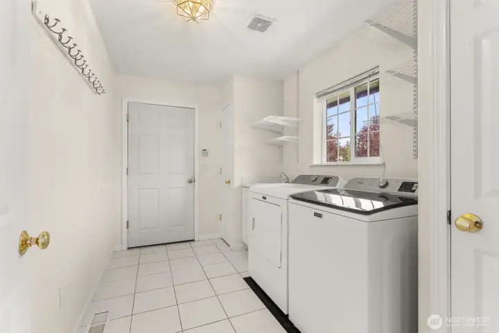Spacious laundry room off the kitchen with window overlooking the front yard