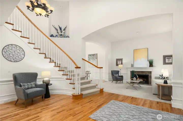 Home flows from family room on left through entry to formal living room with arched entry and wood burning fireplace.  White wainscotting adds refinement to these areas.  Art niche adorns entry with special collections.