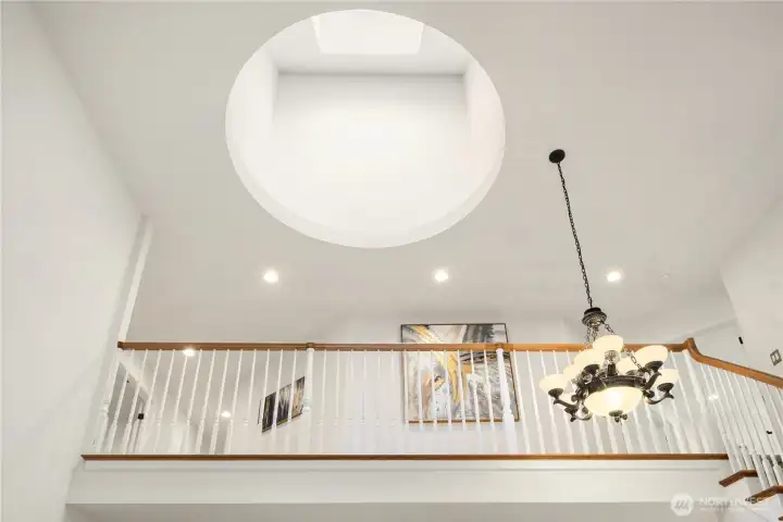 A massive, dramatic skylight floods the entry and second floor with light.  This custom feature accentuates the grand feeling of the home when people enter.  The gorgeous chandelier adds light and grandeur.