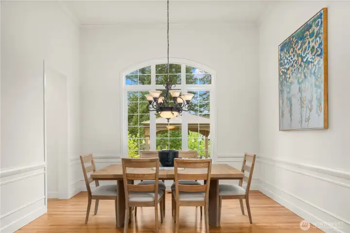 Huge arched window in formal dining room overlooks a rose garden, gazebo, Cascade mountain views to the northeast, and private backyard with green space.  Convenient kitchen entry on left is great for entertaining.