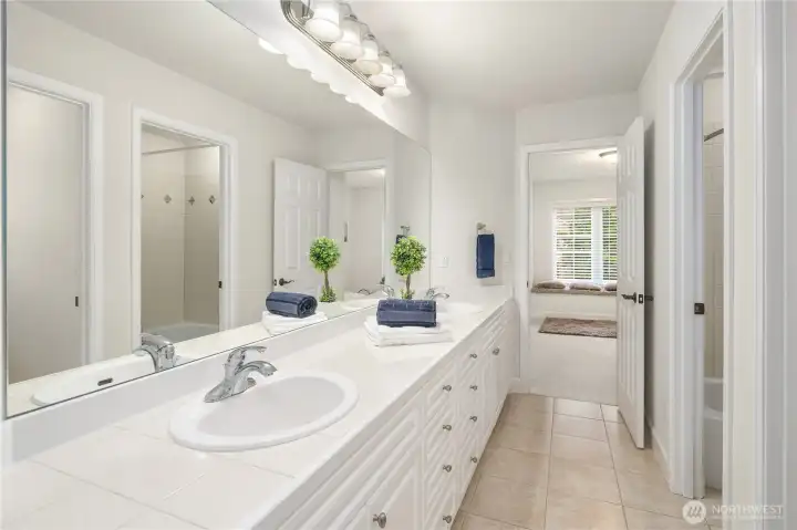Another pristine spacious bath with dual sinks connects the Jack and Jill bedrooms and completes the suite.  On right are two separate rooms, one for the bathtub/shower and one for the commode.  Great set for privacy!
