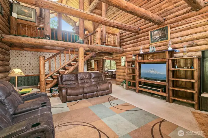 Living room has huge vaulted ceilings. The staircase to the upstairs. Living room has huge vaulted ceilings. The staircase to the upstairs.