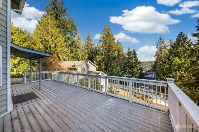 On the east side of this home is this large deck, 2 seating areas, from the far right is a small water and mountain view.