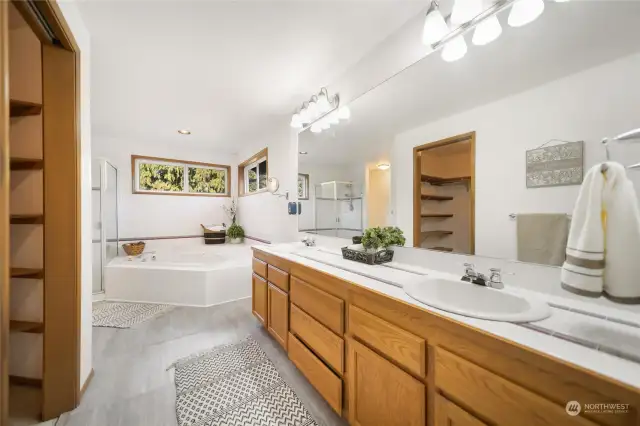 One of the luxurious bathrooms located on the primary floor features an en-suite bath. This well-appointed bath includes a 5-piece design, a corner garden tub, and an enormous walk-in closet.