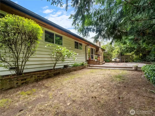 The back yard has a large stone patio but is waiting for someone make great use of the space available. What will you do? A rose garden? A play ground?