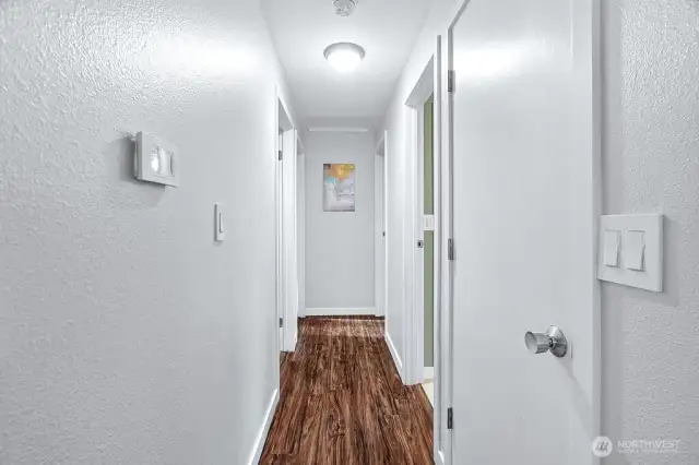 Hallway to all bedrooms and full bath which opens to the primary bedroom