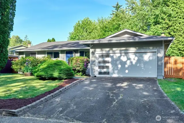 ?? Charming Curb Appeal in a Serene Setting!  Welcome to this beautifully maintained single-level home nestled on a quiet street, surrounded by lush greenery and mature landscaping. The inviting front yard features manicured flower beds, vibrant shrubs, and a wide driveway leading to a modern two-car garage with stylish frosted paneling. Fresh exterior paint, updated lighting, and a welcoming entryway give this home a clean, contemporary look while preserving its classic charm. Don’t miss your chance to own this peaceful retreat with fantastic curb appeal