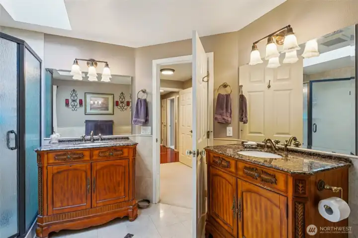 The en-suite bathroom offers 2 separate sinks, storage cabinets, Travertine flooring and more.