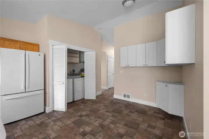 View from kitchen toward entryway, laundry closet, and kitchen nook. Notice vaulted ceilings continue throughout entire living areas.