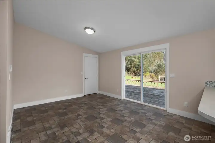 View from kitchen into your second living or flex space. Truly make this your own and utilize how you would like. Bonus - the kitchen and additional space are directly off your slider to the expansive re-finished back deck, providing the ultimate indoor, outdoor living experience. Door to rear leads to over-sized 2 car garage with built in storage and generator hook up.