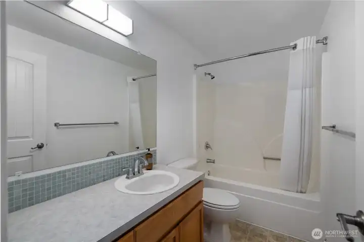 Guest bathroom is easily accessible off living space and off guest bedrooms in hallway. Large vanity and full sized shower make this space very usable.