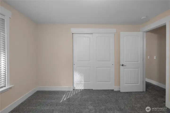 Alternate view of bedroom number one showcasing your large closet and light filled window to the left. View of hallway through doorway with bathroom across the hall. New carpeting and fresh paint!