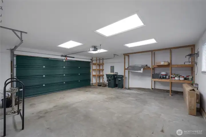 View of interior of attached 2 car garage with built in storage! Tons of room to park, for projects, etc. Entrance to second living space from garage into home.