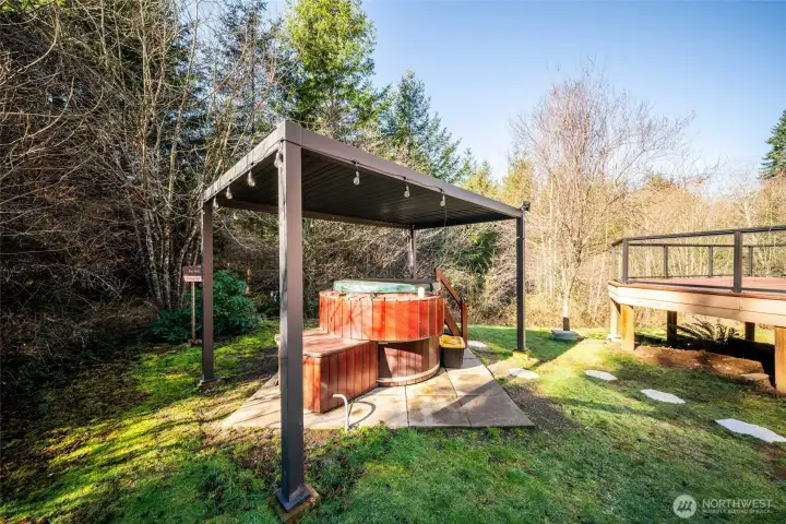 Hot tub just off the deck with a pergola cover.