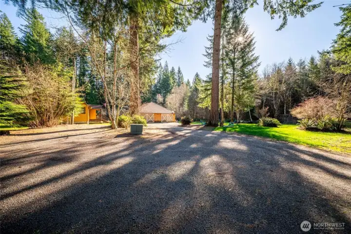 Down the driveway you'll find the separate 2 bedroom, 1 bath cabin and workshop. Surrounded by a big flat lawn and fruit trees as well as mature evergreens. Like a park!