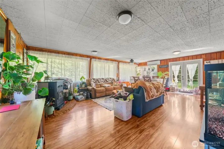 Cabin living room. Lots of natural light. Laminate floors, mini split for heating and cooling plus a pellet stove if you really need to warm up!