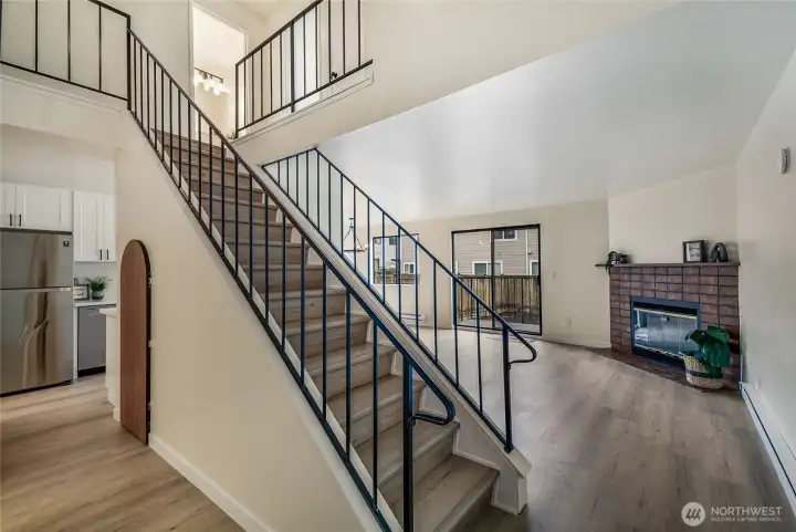 Open floor plan with iron railing. Half bathroom on the left.