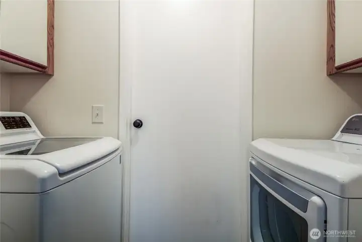 Utility room with washer and dryer from garage to kitchen.
