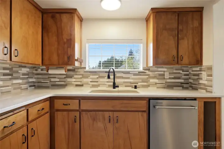 Newer quartz countertops with tile backsplash.