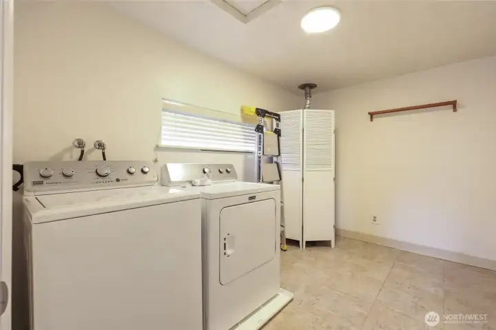 Utility room with washer and dryer staying with the home.