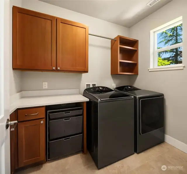Laundry room with built-ins and quartz countertops.