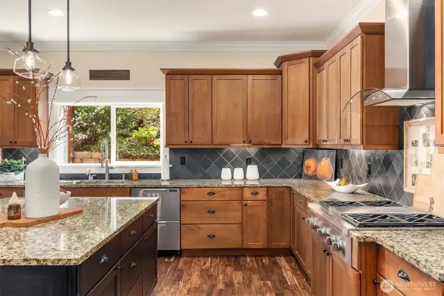 Built-in stainless-steel appliances, slab granite surfaces, & stylish tile backsplash.