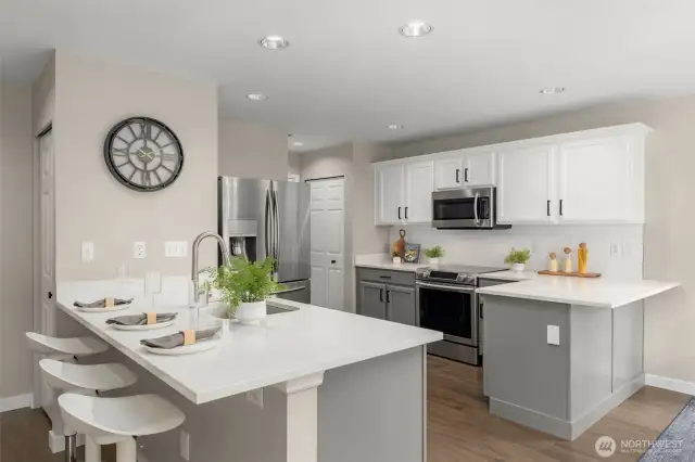Kitchen has modern updates with quartz countertop, subway tile backsplash and ss steel appliances. Also note the kitchen pantry in the corner.