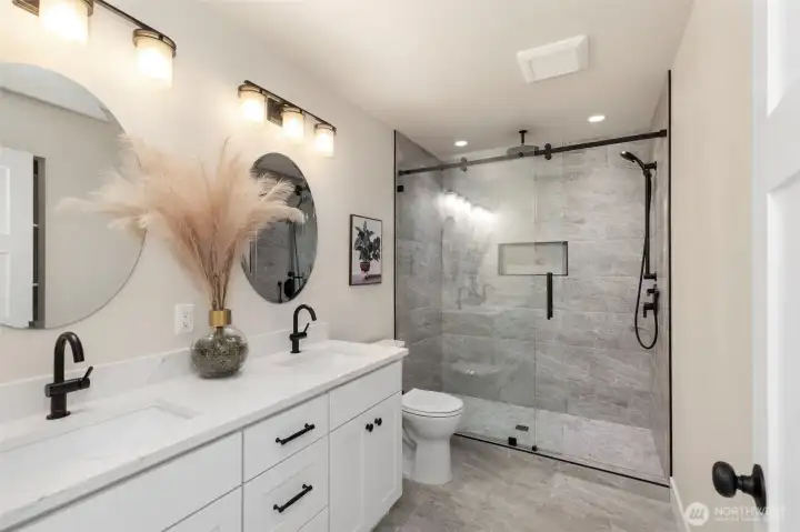 Primary suite bath with heated tile floor, double vanity and spacious shower.  Even wired for new owner to add a bidet if desired.