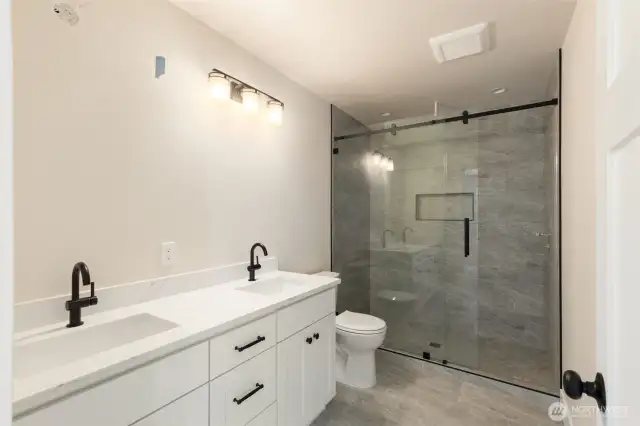 Primary suite bath with heated tile floor, double vanity and spacious shower.  Even wired for new owner to add a bidet if desired.