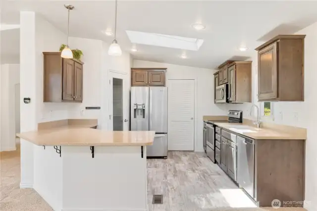 The kitchen is very functional and there is a large pantry next to the refrigerator.