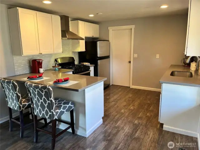 Shaker cabinets, quartz counters, stainless appliances, undermount sink, and tile backsplash.