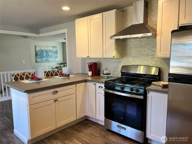 Shaker cabinets, quartz counters, stainless appliances, undermount sink, and tile backsplash.