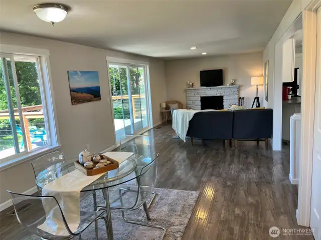 Great room with fireplace, deck access opens to dining space and eat-in kitchen.