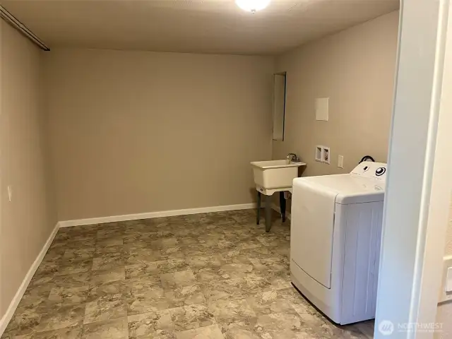 Utility room with dryer and utility sink.