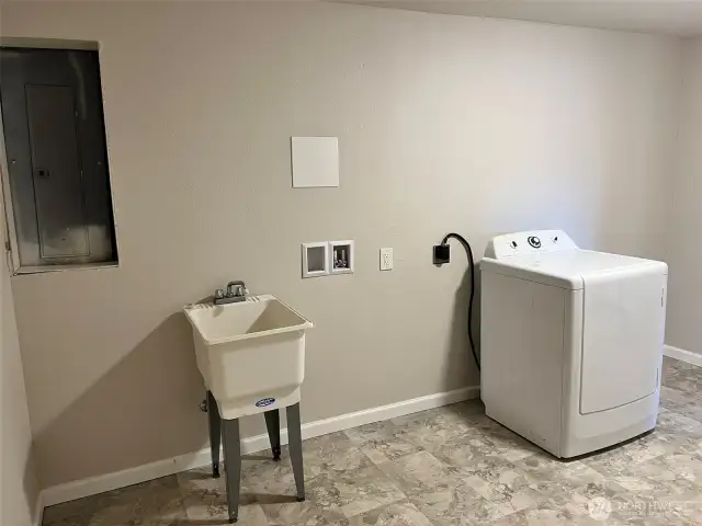 Utility room with dryer and utility sink.
