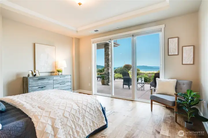 Wake to water and sky in a primary suite designed for serenity—featuring expansive windows, rich hardwoods, and uninterrupted vistas that stretch to Vashon Island and beyond.