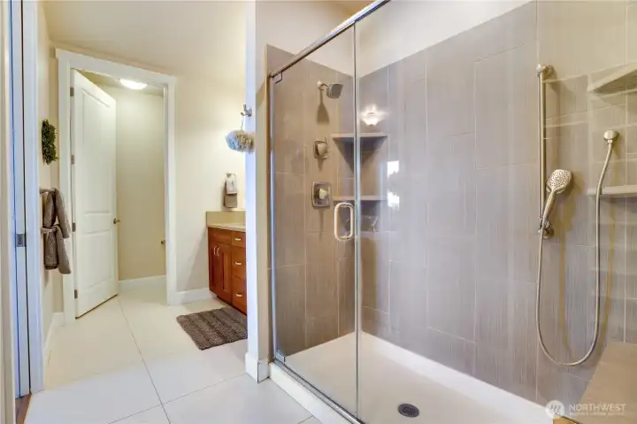 A spa-inspired retreat with timeless tile floors, dual sinks, and abundant storage—centered around a generous walk-in shower designed for daily indulgence.