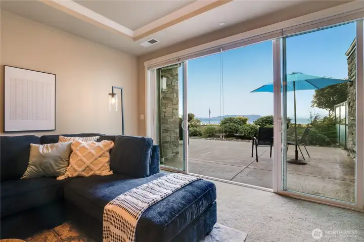 A space designed for connection and calm—tray ceilings and crown molding add polish, while sliding doors open to a patio alive with movement, light, and Sound-side serenity.