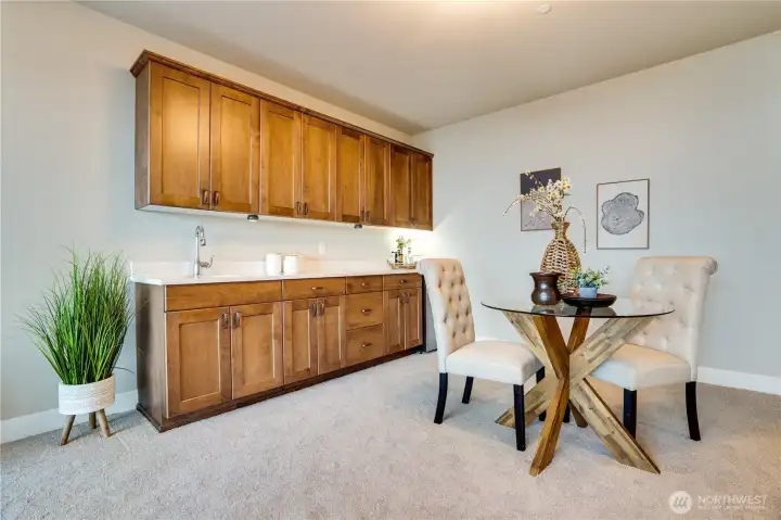 Let’s step back into the family room for a final look at the handsome wet bar, thoughtfully appointed with a sink, mini fridge, generous counter space, and custom built-in cabinetry. Whether styled as an elegant entertaining hub or used to store snacks, beverages, and games, this versatile feature adds both charm and convenience. With the addition of a microwave, coffee maker, or toaster, the space easily transforms into a lavish guest suite—especially with the attached full bath offering comfort and privacy...