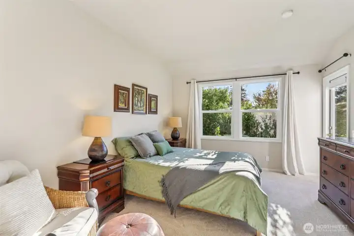 Big bedroom with privacy shrubs outside the windows.