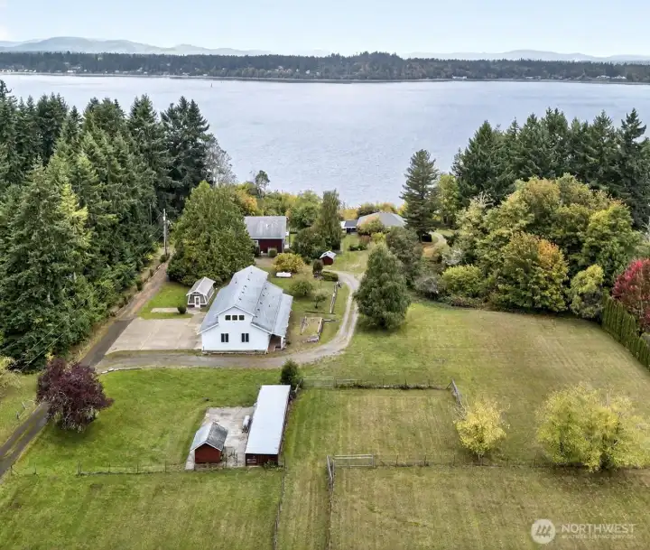 Areal View...Boston Harbor area with high bank water frontage, 2 separate homes, large garage/shop/office, goat shed, storage shed, green houses and fenced pasture land.