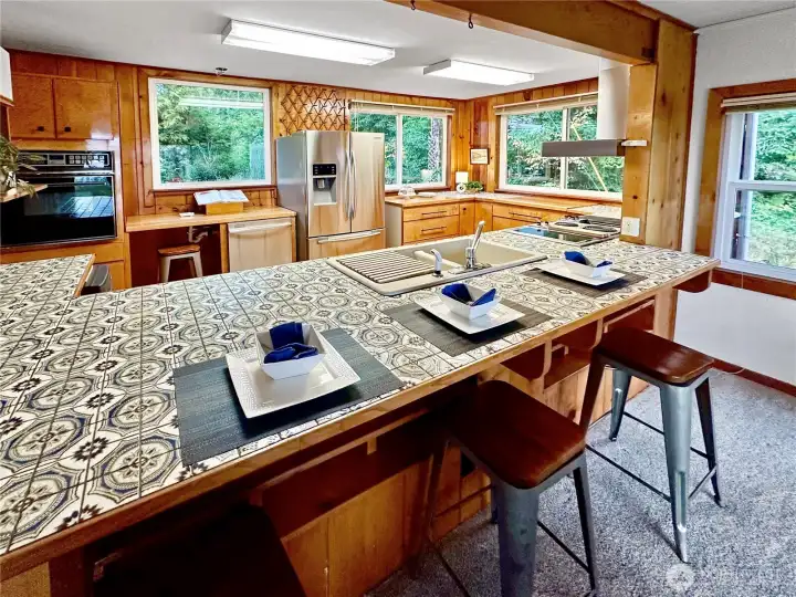 4403...Looking through the kitchen from the family room.  The kitchen offers a large eating bar, tile counters, laminate floor and custom built cabinets.