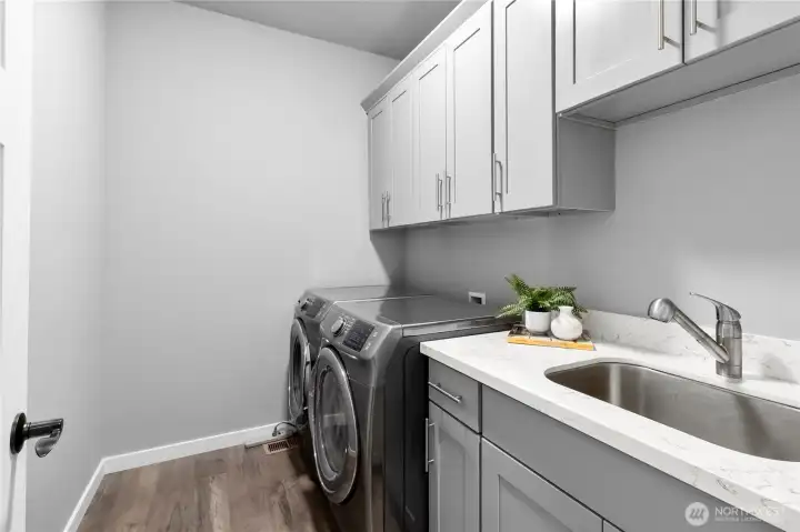 Laundry room on main floor with plenty of storage and sink