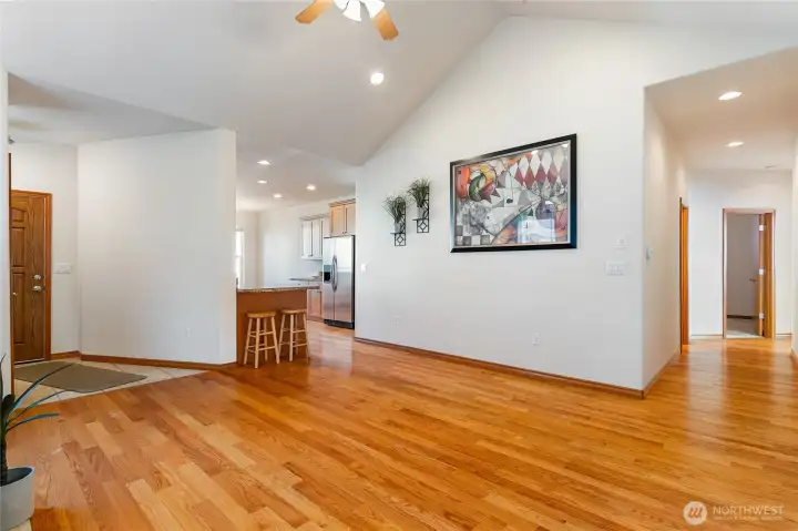 The hardwood floors really stand out as an added element to this home. A full bathroom is located behind picture wall ahead.